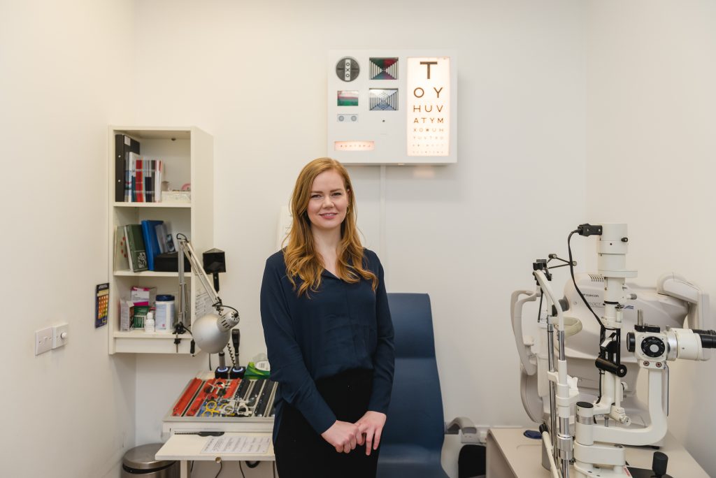 Optometrist Gemma Hill stood in an eye examination room