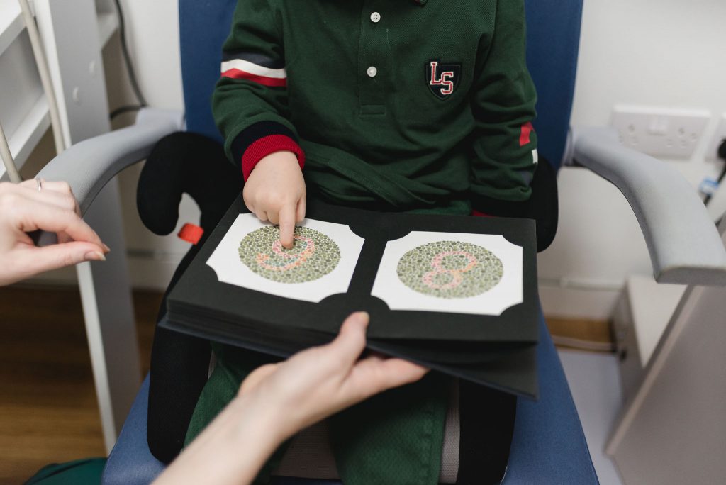 A child points at an image in a colour-blindness test
