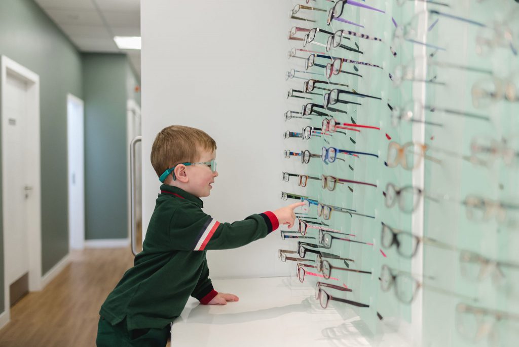 A young boy selecting from our range of children's eyewear